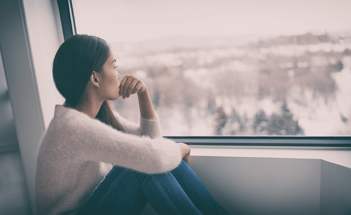 Sad woman sitting down and looking out window