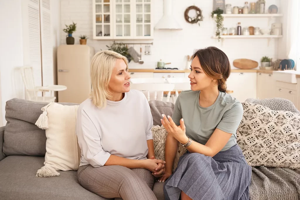 Two women talking to each other intently.