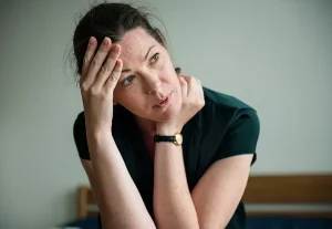 Woman looking stressed, head in hands, leaning over