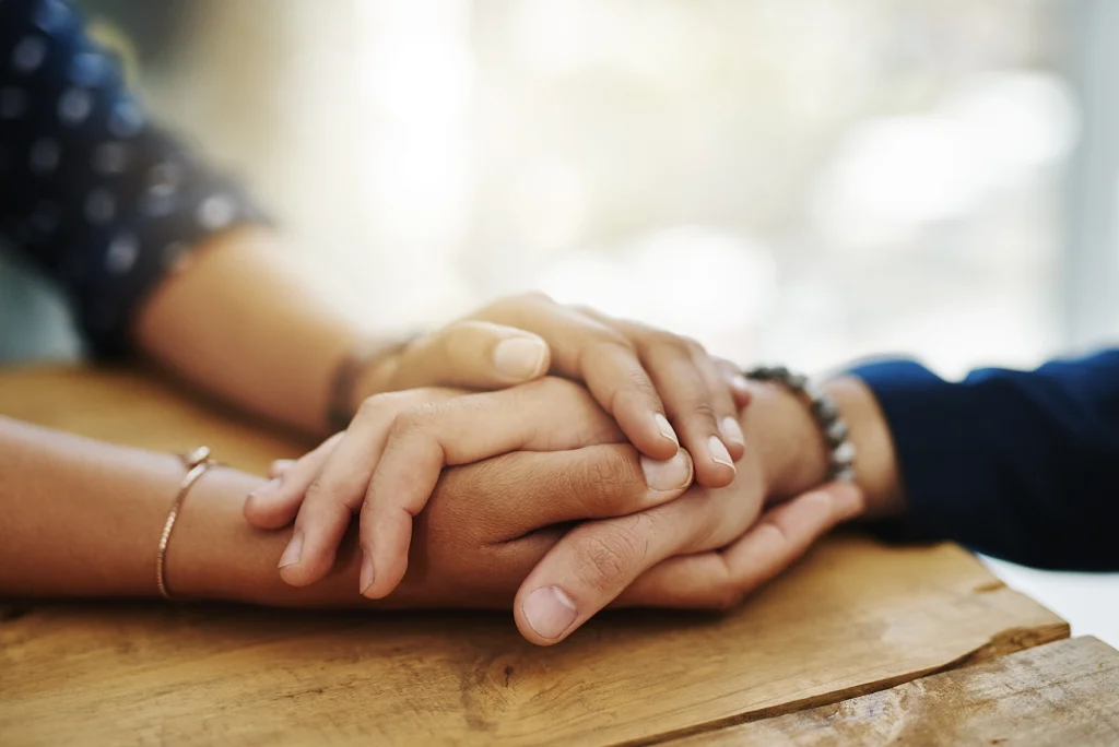 People grieving and holing hands